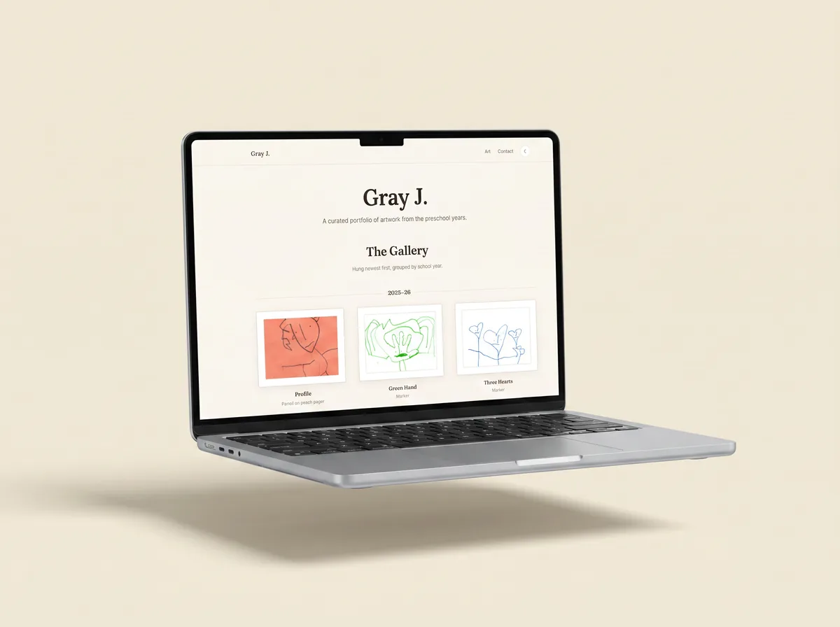 A laptop showing Gray's gallery — a light cream paper website with white-matted framed preschool artwork.